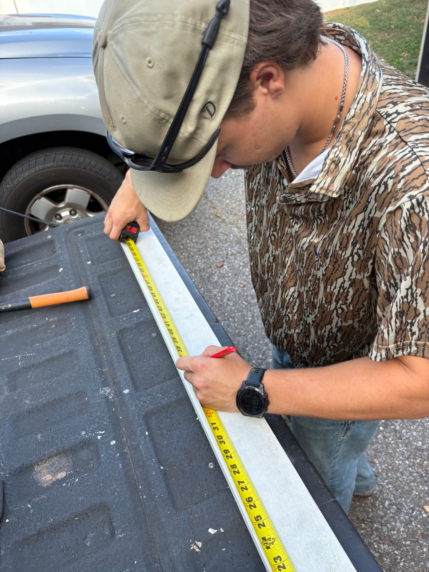 Carpenter measuring and marking trim on a truck tailgate