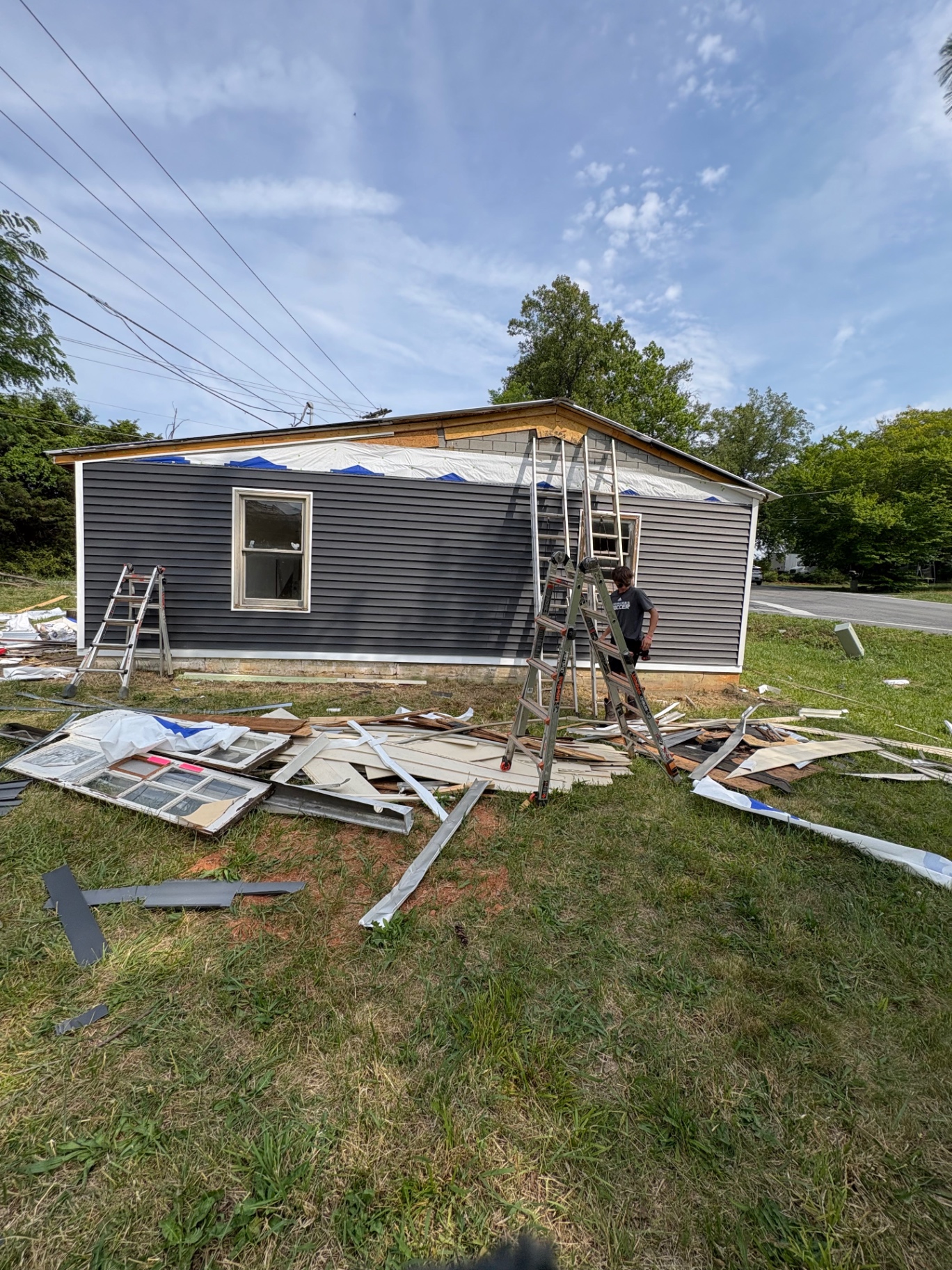 Exterior siding and window replacement in progress on a ranch home